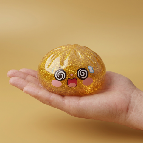 Gold Dumpling Squishy Chance – Gouden Geluksdumpling in de hand gehouden, echte grootte