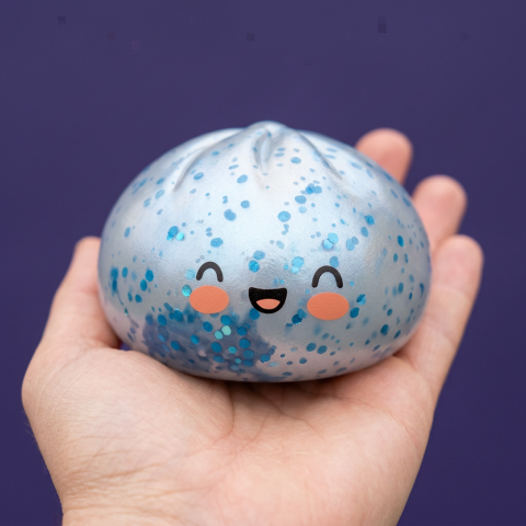 Dumpling Squishy Bleu Glacé Sparkle met Glitter in de hand gehouden, echte grootte