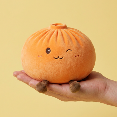 Giant Dumpling Squishy Oranje XXL Knuffelkussen in de hand gehouden, echte grootte