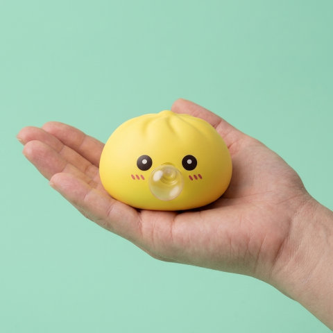 Jumbo Dumpling Squishy Geel met Bamboe Mandje in de hand gehouden, echte grootte