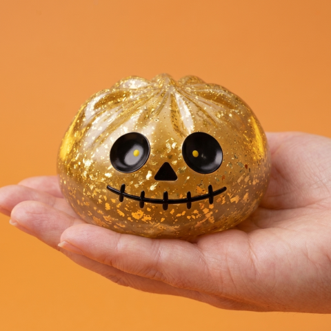 Dumpling Squishy Zombie Halloween Glitter Goud in de hand gehouden, echte grootte